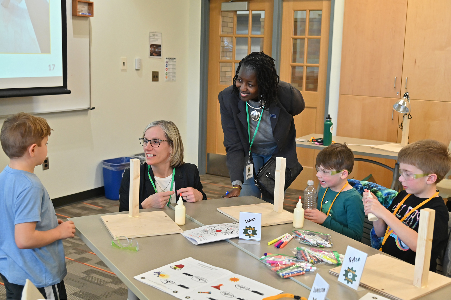  Gwen Sanders (standing), senior community relations manager in National Grid's Customer and External Affairs, and Laura Spenceley, dean for the School of Education, visited the KidsTech program April 9 and talked to organizers and students.