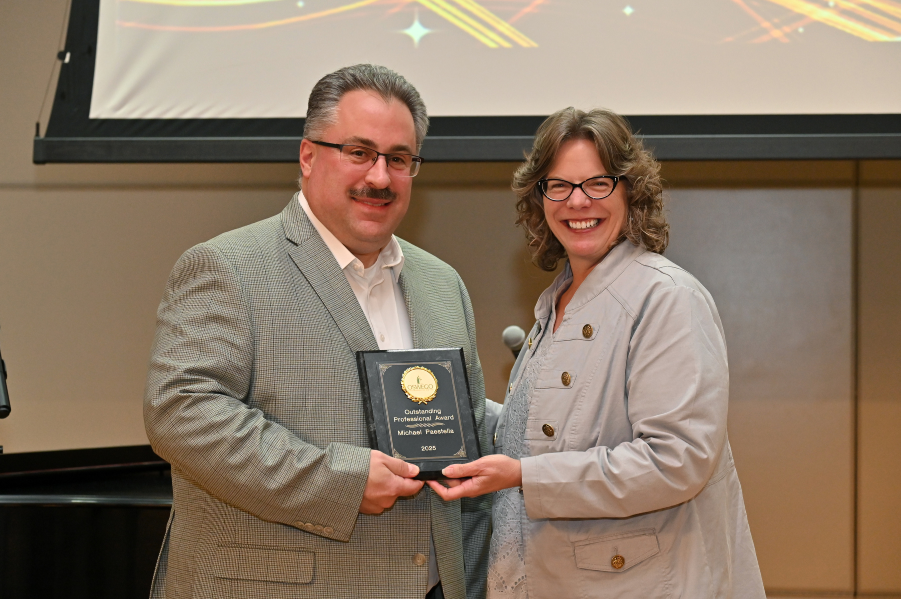 The Student Leadership Ceremony organized by the Divisions of Academic and Student Affairs recognized student leaders as well as the achievements of SUNY Oswego's clubs, organizations and supporters. Michael Paestella, who is now the university’s director of alumni engagement after distinguished service in the Student Engagement and Leadership Office, earned the 2025 Outstanding Professional Award. Presenting is Vice President for Student Affairs Kathleen Kerr.
