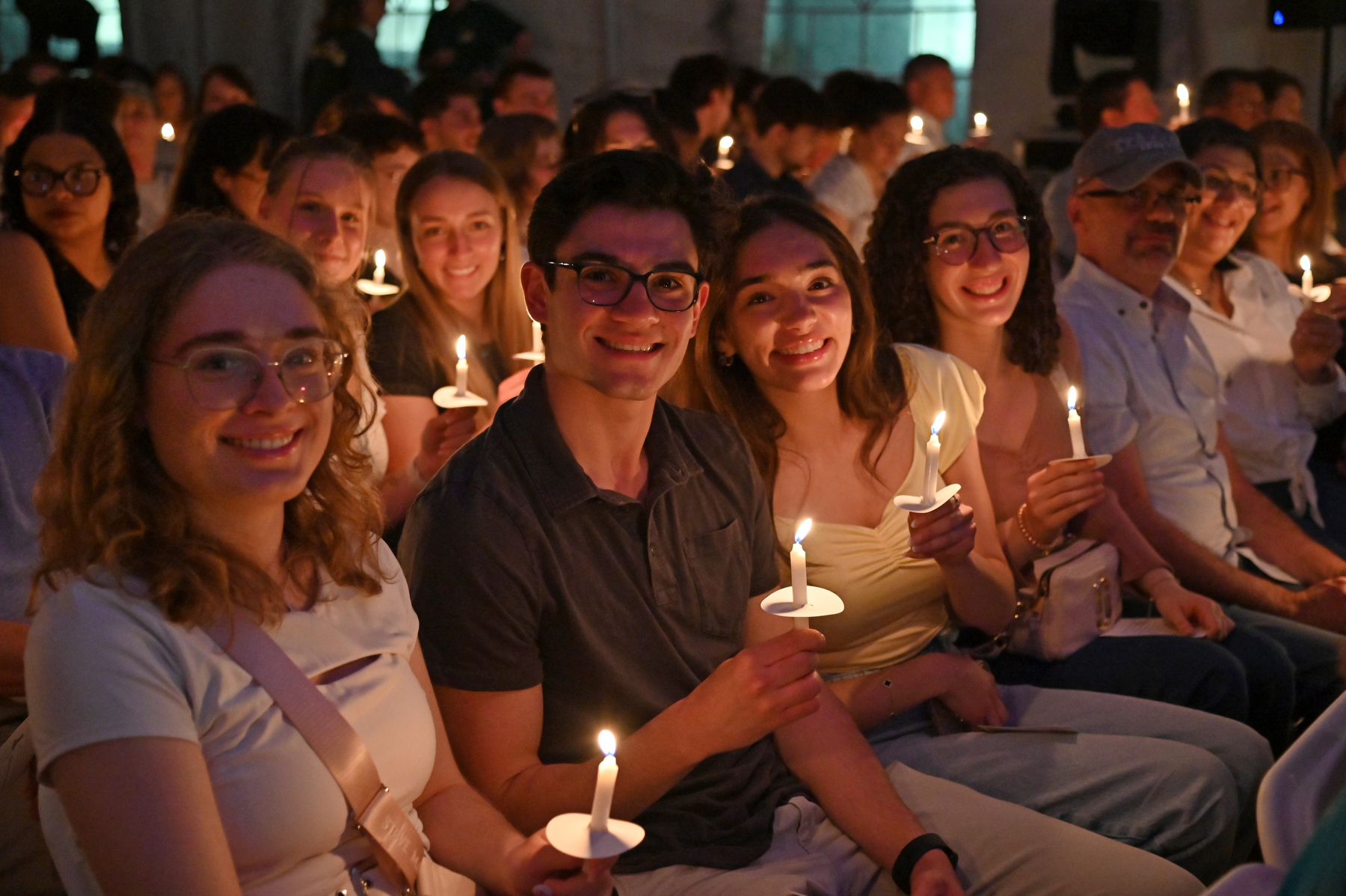 Members of the Class of 2025, families and friends pass the flame of learning during the Commencement Eve Torchlight Ceremony on May 16.