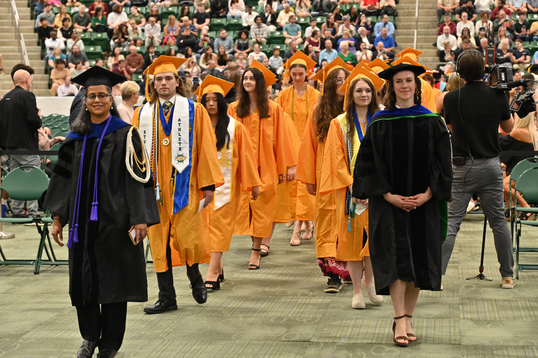 Honors graduates enter the hall for the 9 a.m. College of Liberal Arts and Sciences led by Marshals Mamta Saxena, associate professor of human development, and Jordan Dalton, assistant professor of anthropology.