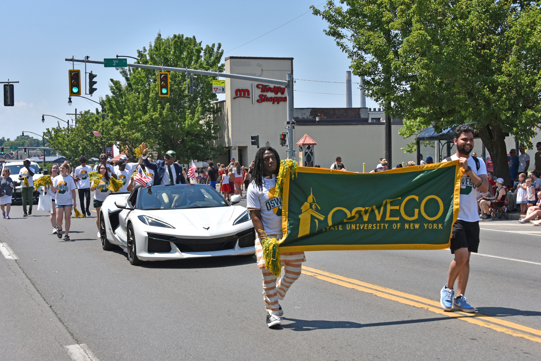 Oswego students join President Peter O. Nwosu, serving as grand marshall, as they participate in Oswego City's Independence Day Parade on July 6. 