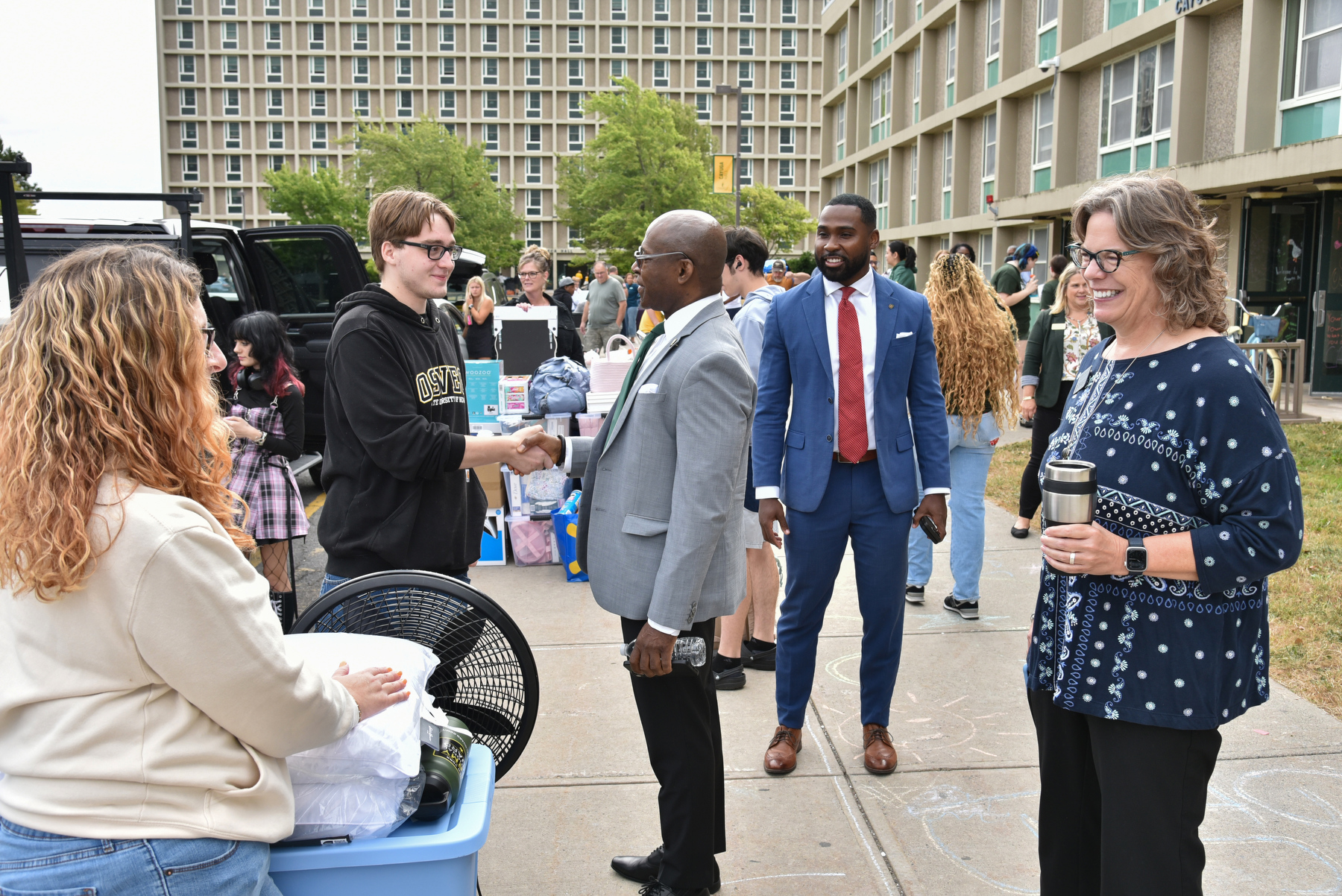 President Peter. O. Nwosu with Kathleen Kerr, vice president for student affairs, Sara Rebeor (pictured in background), assistant vice president of residence life and housing, and Jamal Coleman, director of operations for the Office of the President, greeted incoming students and their families as they moved into west-end Oneida and Cayuga first-year residence halls, and then visited lakeside Johnson and Riggs halls.