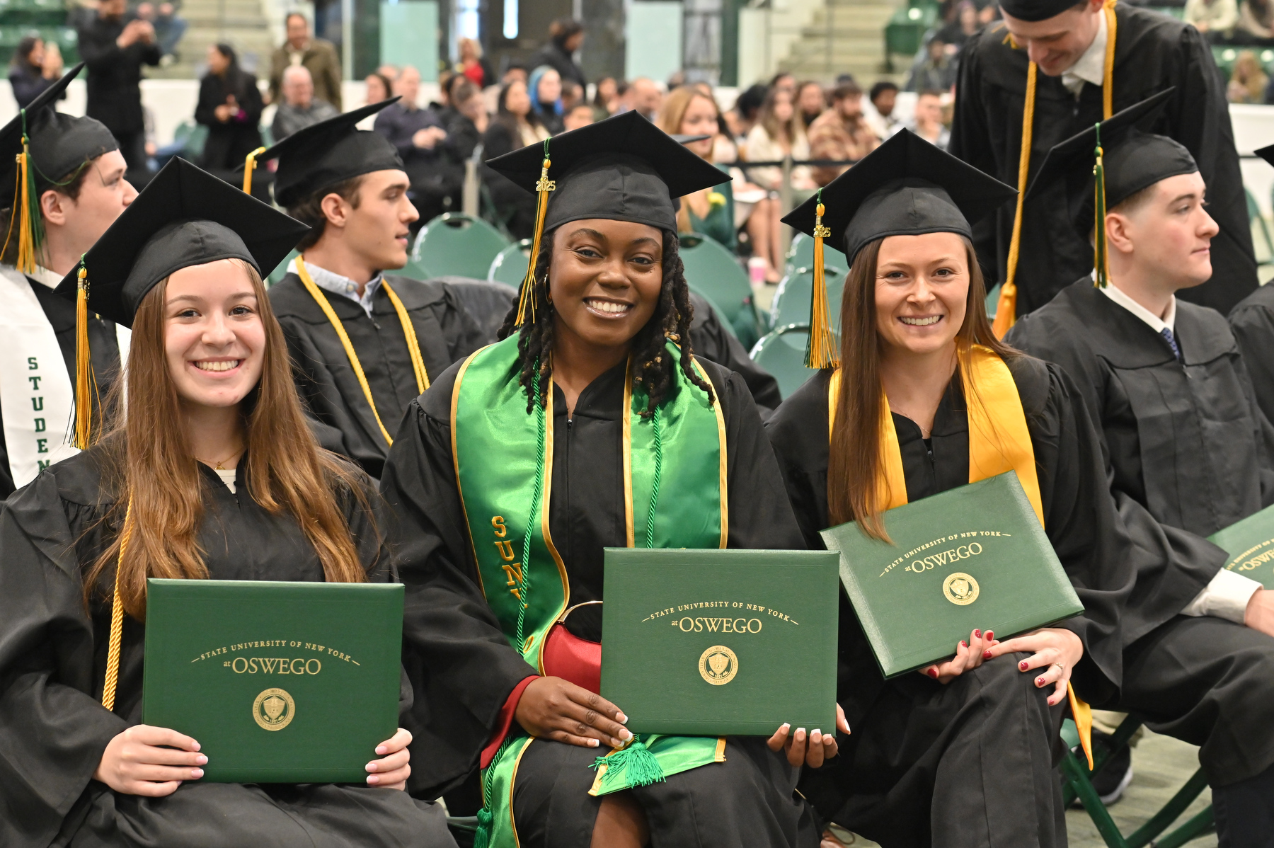 Graduates show their pride after walking across the platform.
