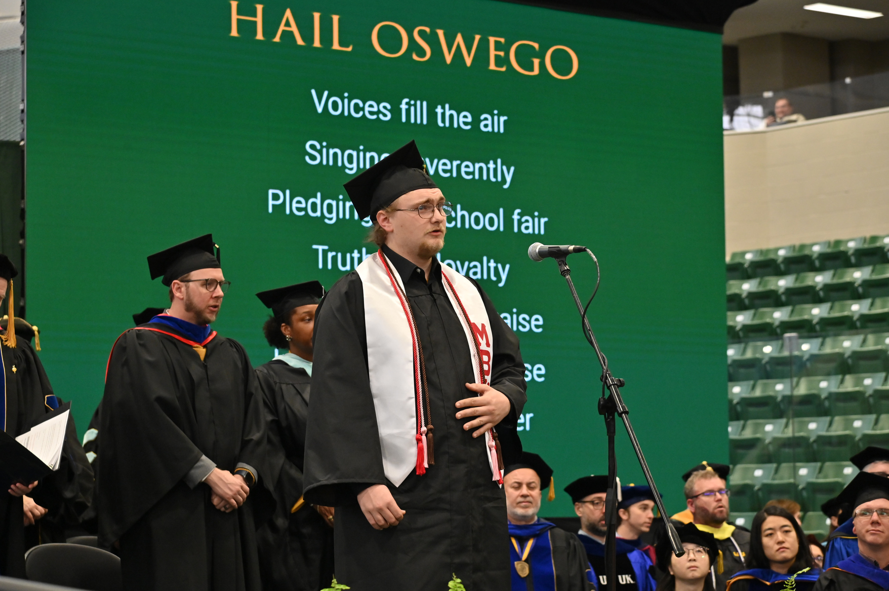 Griffin Marriner leads the singing of the Alma Mater toward the conclusion of the December Commencement.