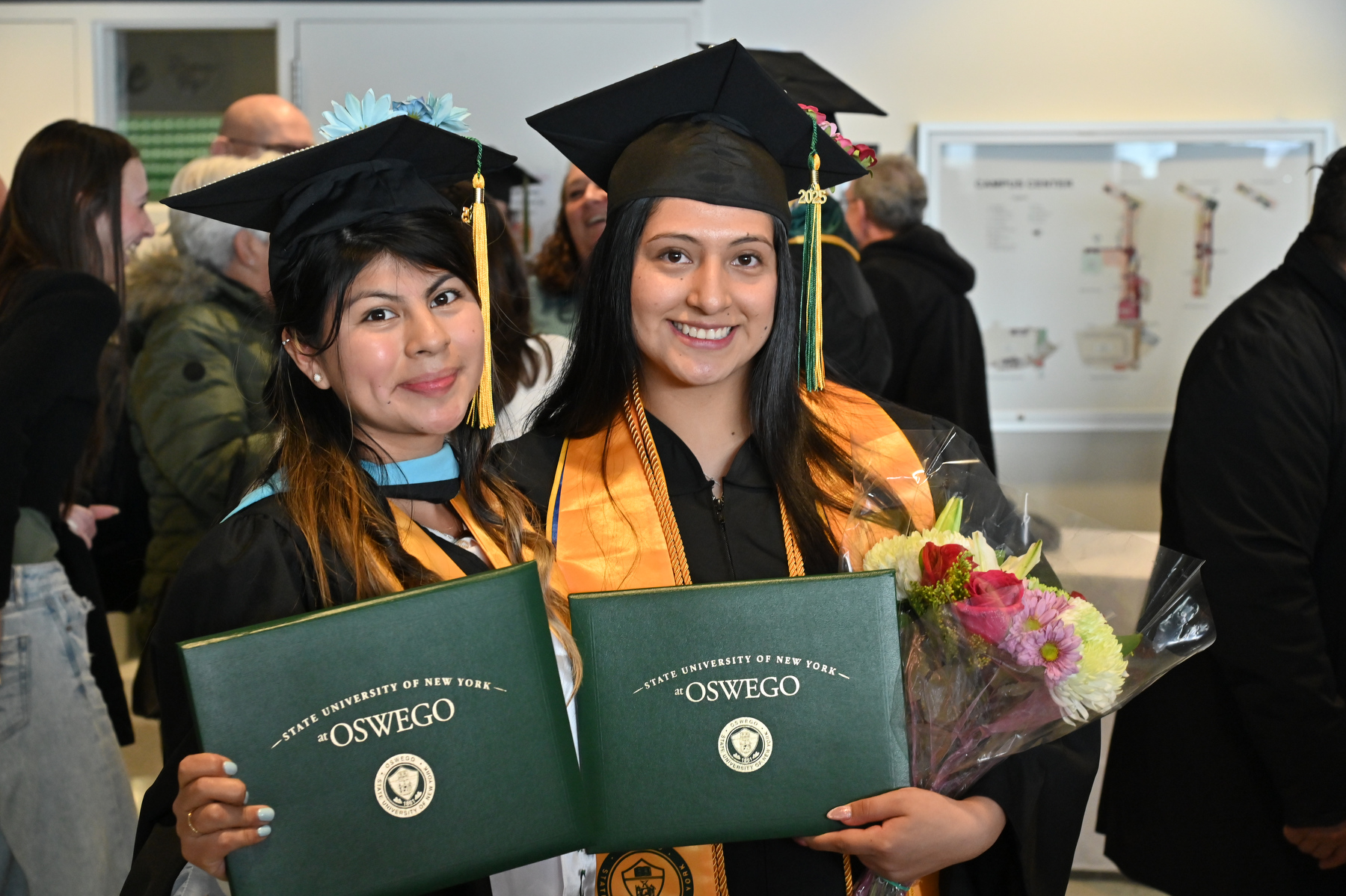 Graduates Maria Juarez (left), earning a bachelor’s in criminal justice, and Cheyenne Sinchico, who earned a master of science in higher education, show joy in their achievements after the ceremony