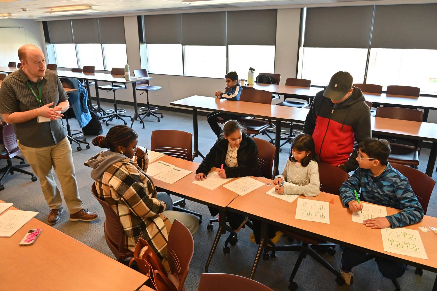 Greg Churchill (left), assistant professor of mathematics at SUNY Oswego, leads a workshop during Community Math Day on May 2.