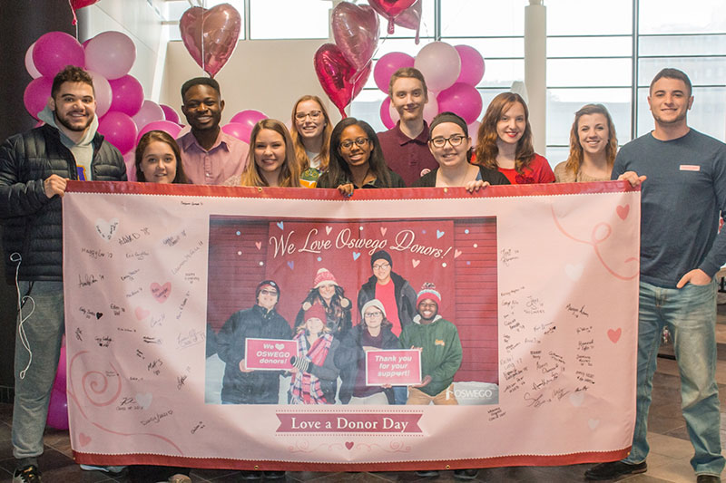 Students pose with banner at Love a Donor Day event