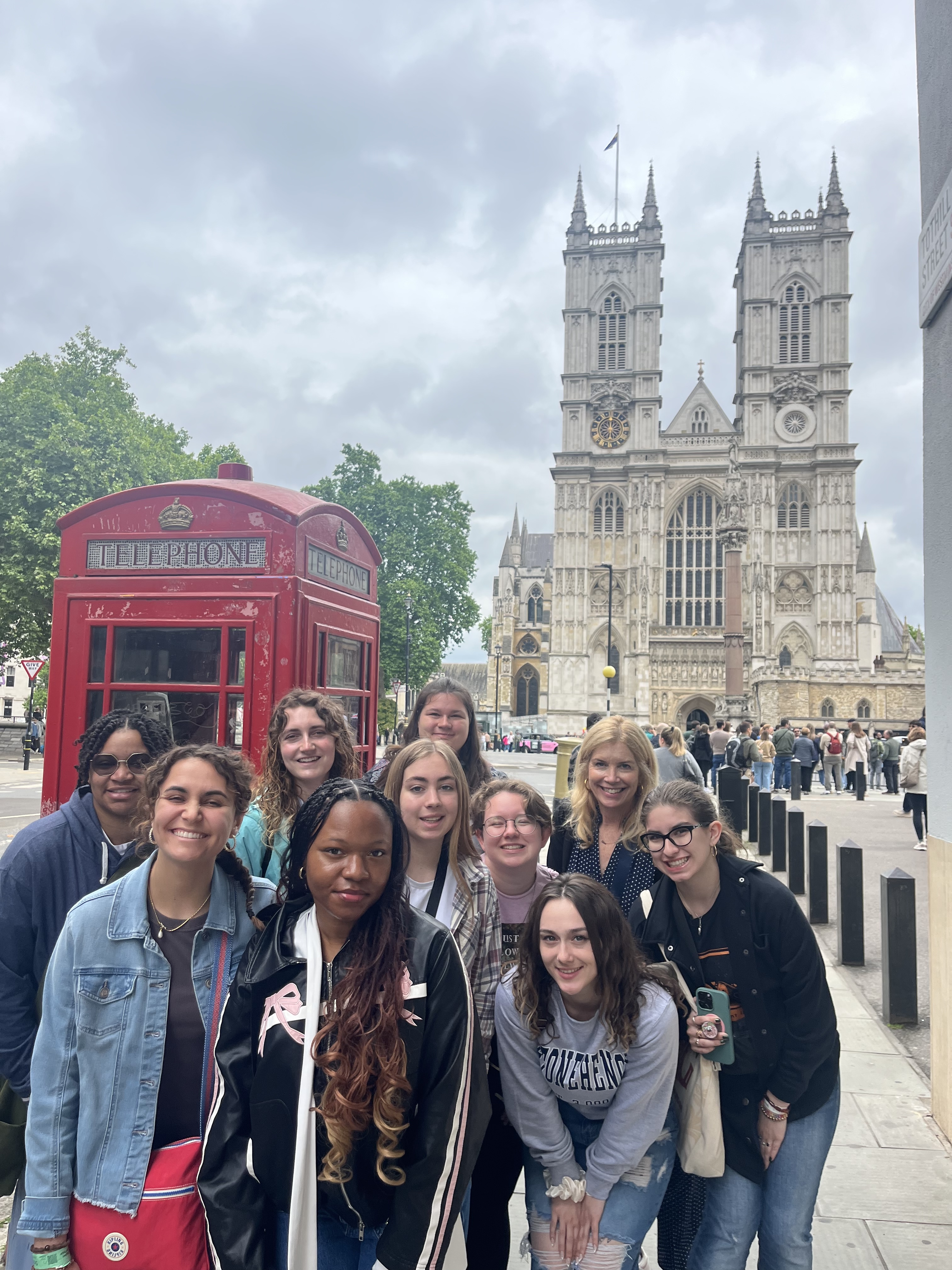 Students in a study abroad program, in front of a red telephone booth and a large cathedral