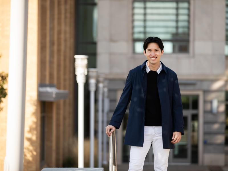 male student standing outside the School of Education