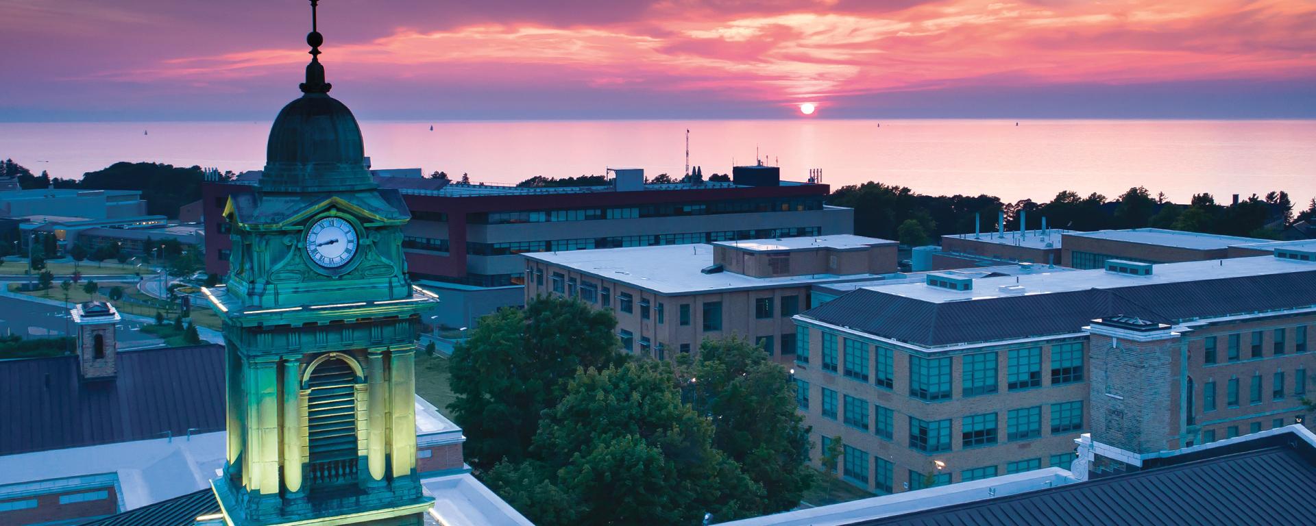 Aerial view of Sheldon Hall in front of a sunset